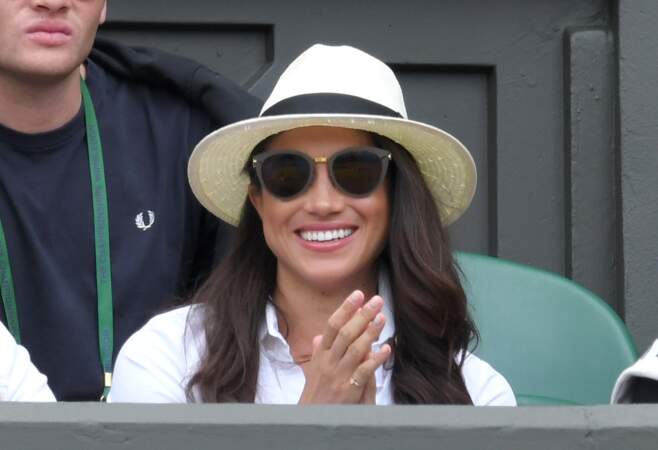 En panama, chemise blanche et lunettes de soleil, Meghan Markle affiche un sourire radieux à Wimbledon en 2016