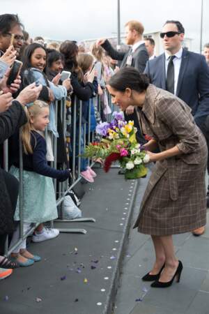 Meghan Markle reçoit un bouquet de fleurs des mains d'une fillette à Wellington, le 28 octobre 2018