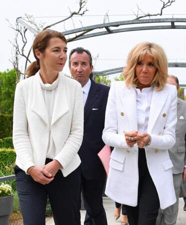 Brigitte Macron très chic et bronzée avec une veste longue signée Alexandre Vauthierqui souligne ses cheveux blonds
