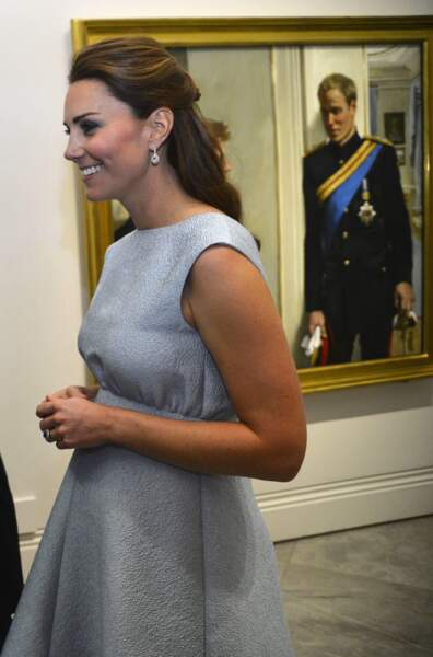 Kate Middleton, enceinte de 6 mois, masquant son ventre avec ses mains jointes, à Londres, le 24 avril 2013.