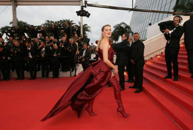 Très sexy en robe et cuissardes rouges Elie Saab, Amber Heard s'apprête à monter les marches