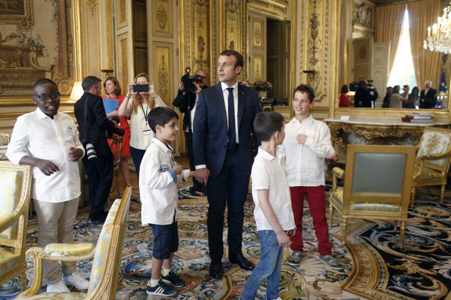 Les enfants tiennent la main d'Emmanuel Macron et passent dans des salons luxueux...