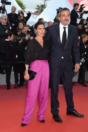 Alessandra Sublet en large pantalon fuchsia et chemisier noir transparent pour monter les marches à Cannes
