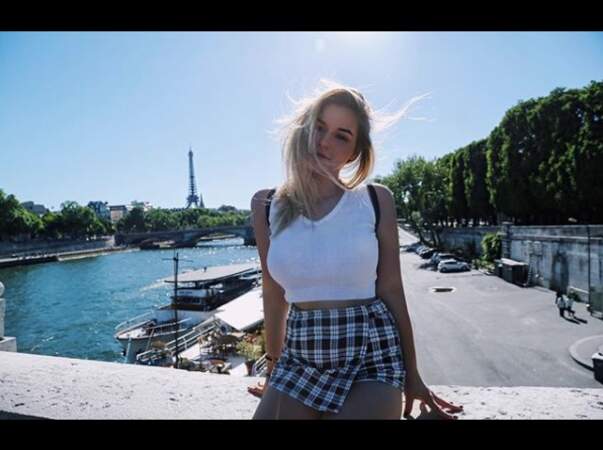 L'été à Paris, Darina Scotti se dévoile, en minijupe à carreaux et crop top moulant asymétrique blanc.