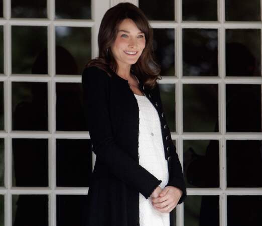 Alors enceinte de Giulia, elle affiche un leger baby bump en robe blanche et longue veste noire à Deauville en 2011