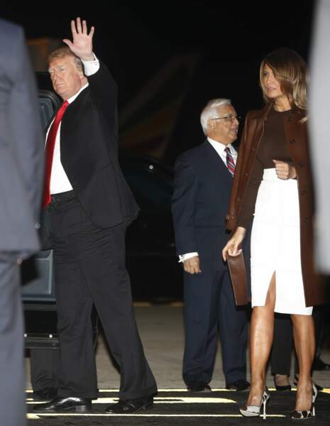 Melania Trump en jupe blanche ouverte et long manteau en cuir