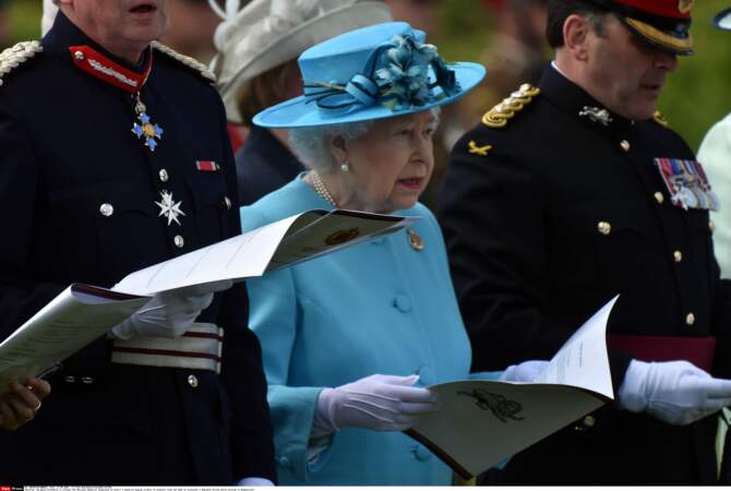 Elizabeth II :trop sage, le bleu pervenche ? Pas du tout : il suffit de le rehausser avec un chapeau aux rubans tarabiscotés