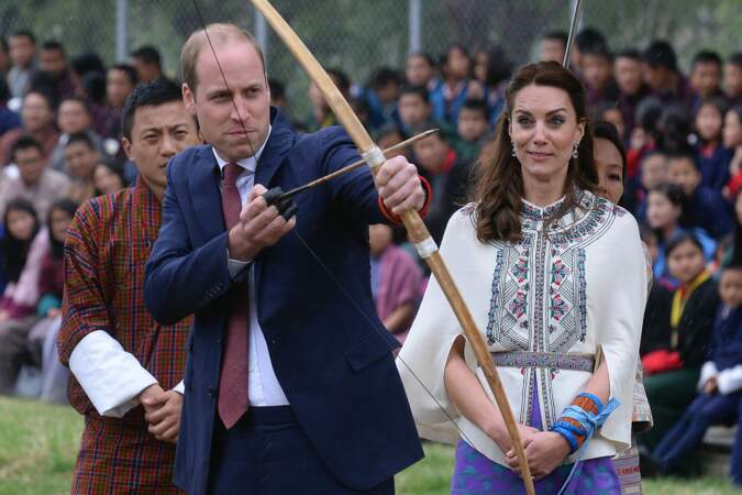 Le prince William concentré avant de tirer sa flèche, devant l'oeil inquiet de son épouse