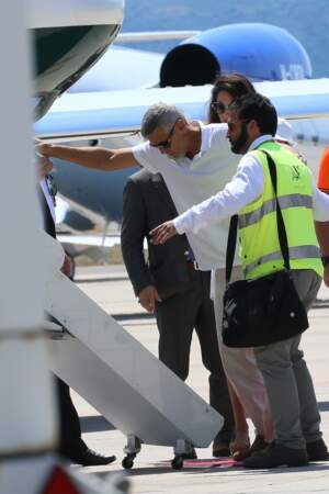George Clooney semble tout de même avoir besoin du personnel au sol pour l'aider à monter à bord de l'avion. 