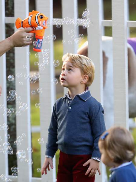 Le prince George fasciné par un pistolet à bulles, lors d'une fête organisée à Victoria le 29 Septembre 2016
