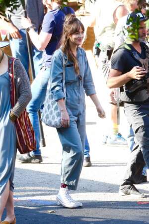 Dakota Johnson associe sa combi en jean à une paire de Converse blanche
