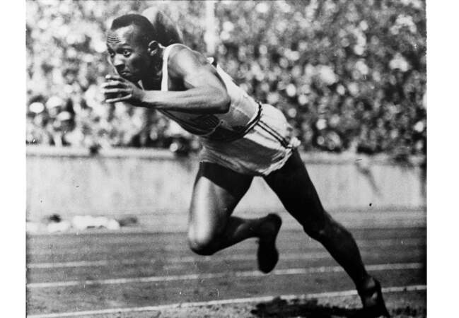L'athlète américain Jesse Owens remporte la médaille d'or sur plusieurs distances aux JO de 1936 devant Hitler