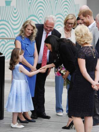 Une petite fille offre un bouquet de fleurs à Meghan Markle lors de son 1er voyage officiel avec le prince Harry