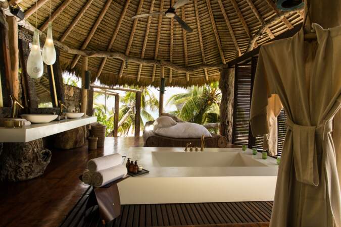 La salle de bains, ouverte sur l'extérieur, offre une vue splendide sur la végétation tropicale