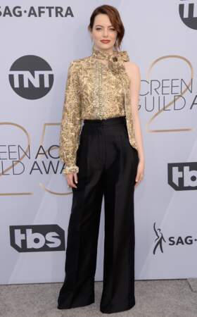 Emma Stone portait un pantalon noir évasé et un haut asymétrique Louis Vuitton lors des SAG Awards 2019.