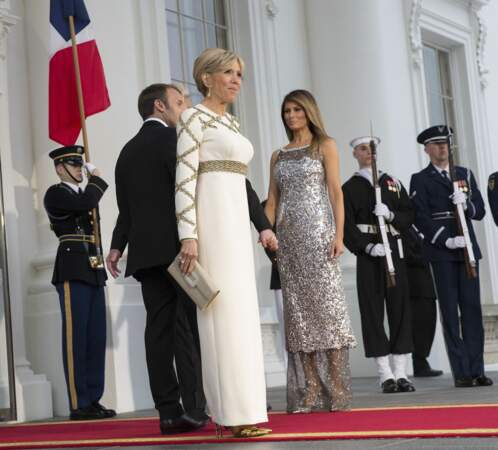 Brigitte Macron en robe de vestale blanche et dorée Louis Vuitton face à Melania Trump le 24 avril 2018