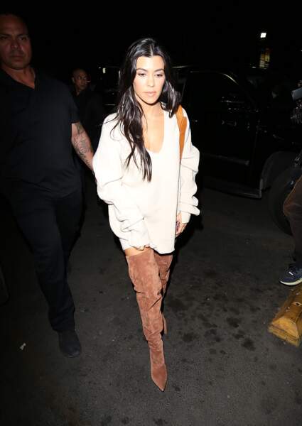 En mode sexy, Kourtney Kardashian détourne son pull oversize en robe accessoirisé de cuissardes en daim. 