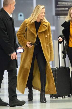 Margot Robbie ose le grand manteau en fausse fourrure jaune avec un total look noir.