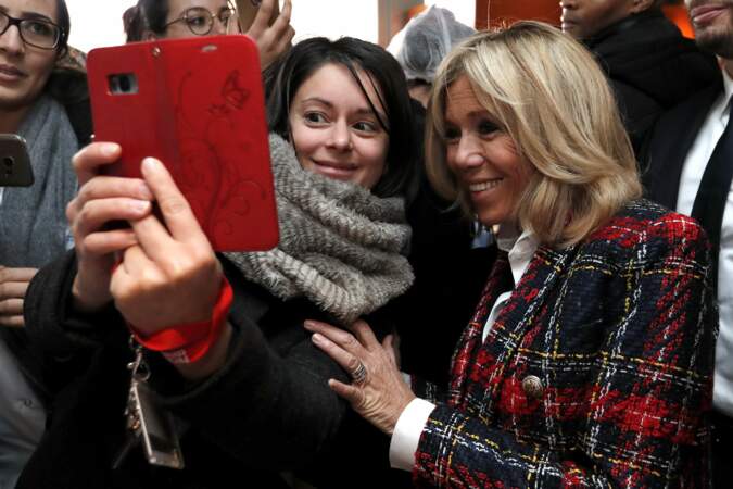 Brigitte Macron très souriante pose avec une fan à l'hôpital de Saint-Denis