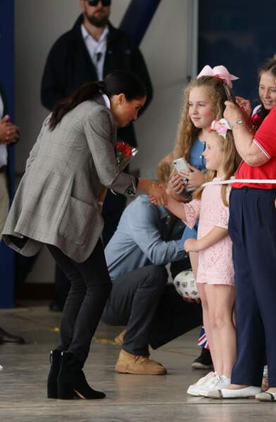 Meghan reçoit un bouquet des mains d'une fillette à Dubbo en Australie, le 17 octobre 2018