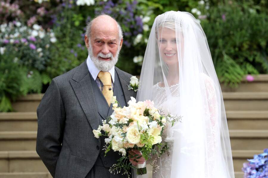 Gabriella en robe de mariée, bouquet de fleurs à la main, et son père Michael