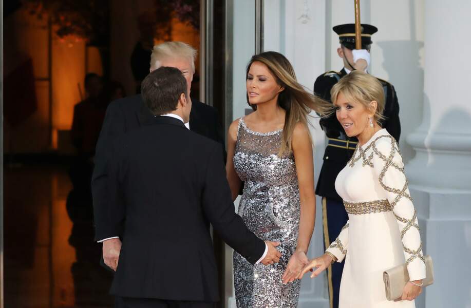 Brigitte Macron en robe de vestale face à Melania Trump en robe Chanel scintillante