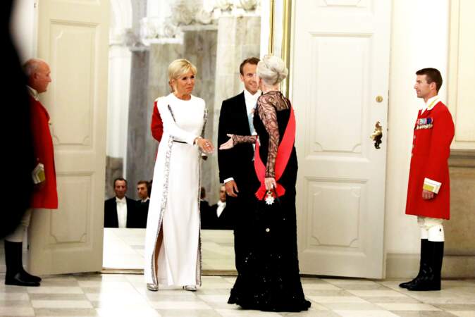 Brigitte Macron porte toujours une robe longue fendue aux motifs argentés lors de ses voyages à l'étranger