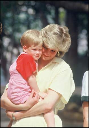 Le prince Harry, adorable dans une salopette à rayures rouges, dans les bras de Diana à Majorque en 1987