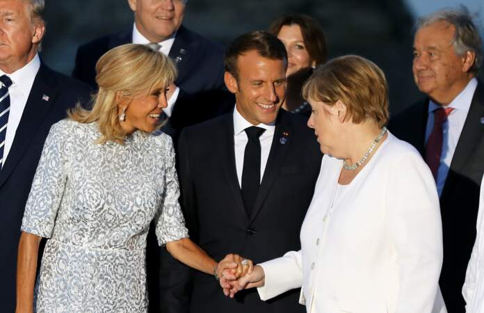 Brigitte Macron conserve son carré blond qu'elle accessoirise d'une paire de boucles d'oreilles assorties à sa robe