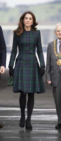 Très cintré, le manteau tartan de Kate Middleton laisse entrevoir ses jambes interminables, réhaussées de talons.