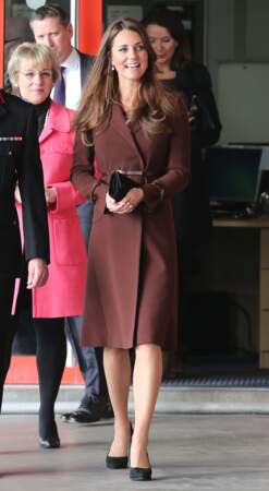 Kate Middleton, enceinte de 5 mois, dissimulant son ventre avec une pochette, à Grimsby, le 5 mars 2013.