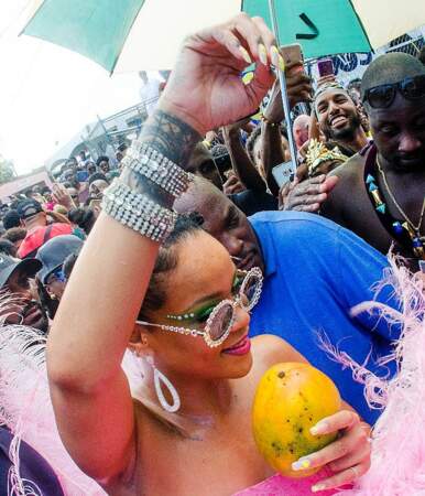 Rihanna arbore son tatouage, ses bracelets, son costume et une mangue