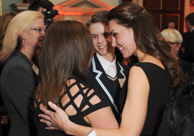 Kate prend dans ses bras la mère en larmes d'un jeune autiste, lors de la soirée  caritative Place2Be