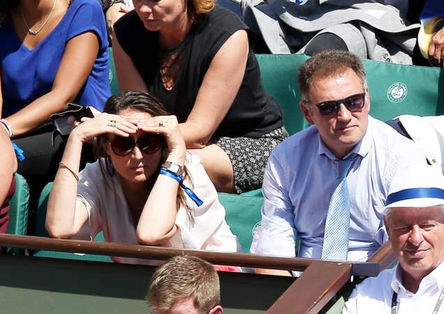 Le soleil tape et la compagne de Pierre Sled se concentre attentivement sur le match à Roland Garros