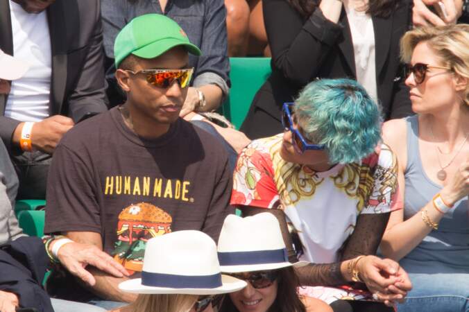 Pharrell Williams caché par des lunettes et une casquette 