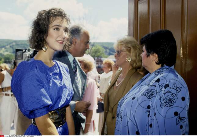 En robe à manches bouffantes et large ceinture, elle assiste à un mariage à Montréal avec René Angelil, en 1987