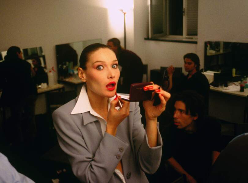 Carla Bruni, chignon ultra lisse et bouche rouge glamour, dans les backstages de la Fashion Week en 1994