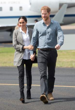 Meghan Markle, enceinte, opte pour un jean noir slim à son arrivée en Australie pour une tenue relax et chic.