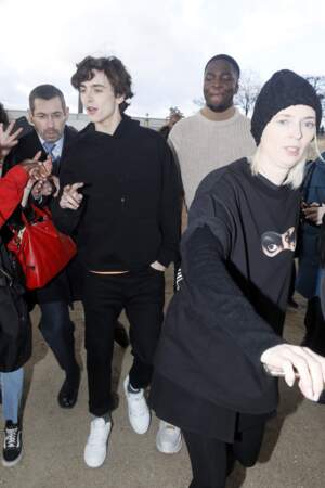 Pull à capuche noir, jeans et baskets signent le look de Timothée Chalamet pour le show Louis Vuitton homme.