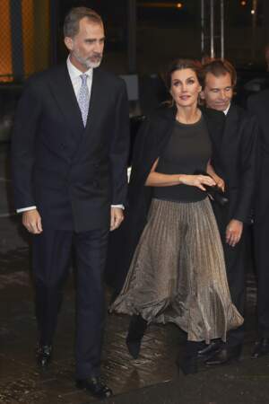 Jupe plissée dorée et haut noir à col rond, la reine Letizia d'Espagne est à 100 % dans la tendance.