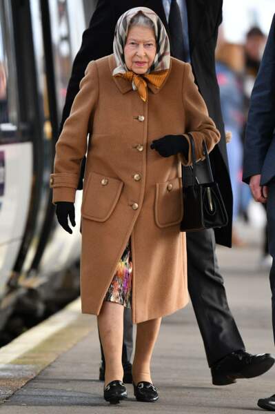 La reine Elizabeth II, en manteau camel et foulard Burberry, lors d'une visite à Sandringham, le 20 décembre 2018