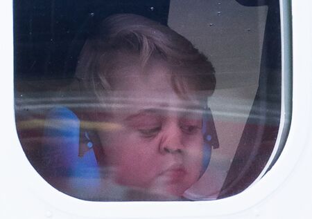 Le nez écrasé sur la vitre de l'avion, le petit prince George observe la piste de décollage