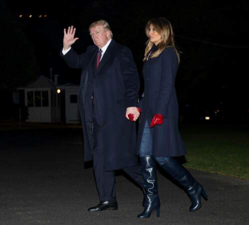 Melania Trump très élégante en manteau long, gants rouges et bottes noires, main dans la main avec Donald Trump