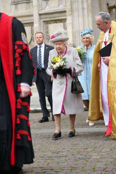 Pour l'occasion, Sa Majesté portait un long manteau beige orné de coutures rose fuchsia...