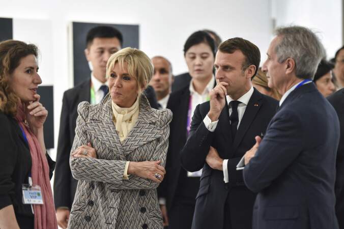 Brigitte Macron à Shanghaï le 5 novembre 2019 très chic avec une blouse crème col lavallière, un petit chignon et un manteau graphique