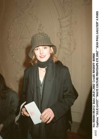 2002 : Julie Gayet a les cheveux mi-longs dans un blond/roux. Elle porte un bob kaki pour le défilé haute couture printemps/été de Jean-Paul Gaultier.