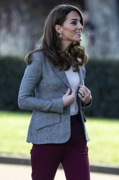 Kate Middleton a choisi un look coloré avec une veste grise, un pantalon bordeaux et un haut blanc.