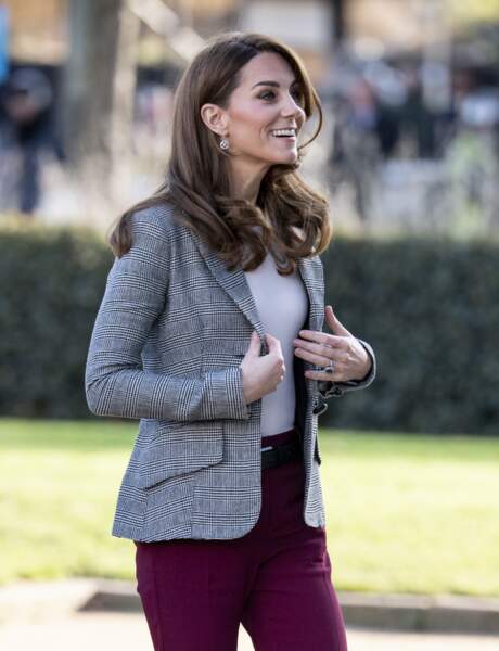 Kate Middleton souriante et chic avec sa veste de blazer Smythe et son pantalon coloré.