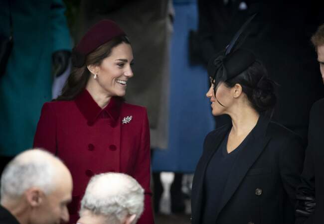 25 décembre 2018 : Kate Middleton et Meghan Markle, souriantes et complices, en pleine discussion sur les marches de l'église de Sandringham.