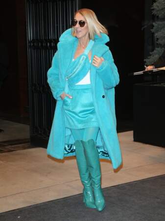 Céline Dion ose le mix manteau long, jupe courte, banane et cuissardes, dans une camaïeu de bleu ciel et bleu canard, le tout signé Max Mara.